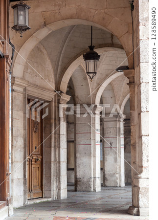 Charming stone arches and wooden door in the historic streets of Burgos, Spain during the afternoon 128589490