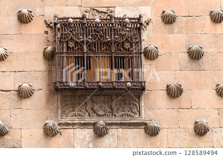 Historic window with ornate wrought iron grill on a stone building in Salamanca, Spain 128589494