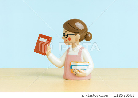 A female bookstore clerk holding a book 128589595