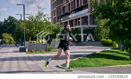 Middle aged man running in city park on sunny day for fitness and health Middle aged man running in city park on sunny day for fitness and health 128589620
