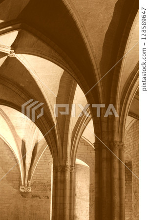 Gothic arches in an ancient stone building revealed by soft lighting Gothic arches in an ancient stone building revealed by soft lighting 128589647