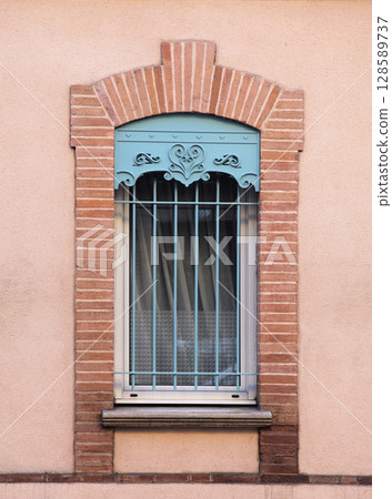 Decorative window design showcasing brick architecture in a residential building Decorative window design showcasing brick architecture in a residential building 128589737