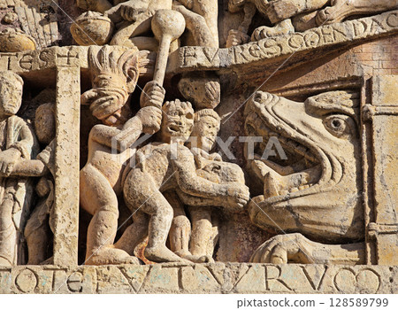 Stone carvings depicting Hell on entrance of Abbey Church of Sainte-Foy in Conques, France Stone carvings depicting Hell on entrance of Abbey Church of Sainte-Foy in Conques, France 128589799
