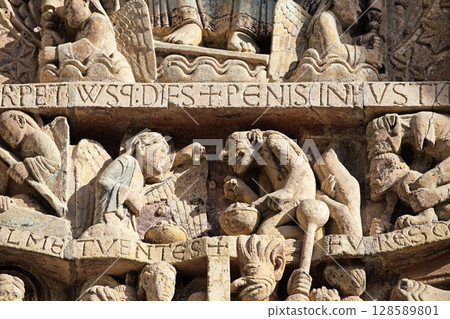 Stone carvings depicting Hell on entrance of Abbey Church of Sainte-Foy in Conques, France 128589801