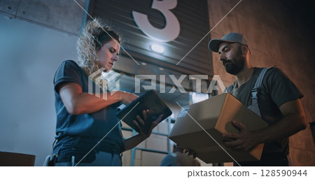 Multiethnic Workers Carrying Cardboard Boxes. Female Inventory Manager Scanning Parcels, Using Tablet Multiethnic Workers Carrying Cardboard Boxes. Female Inventory Manager Scanning Parcels, Using Tablet 128590944