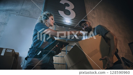 Female Manager Scanning Parcels, Using Digital Tablet. Diverse Employees Carrying Cardboard Boxes 128590960