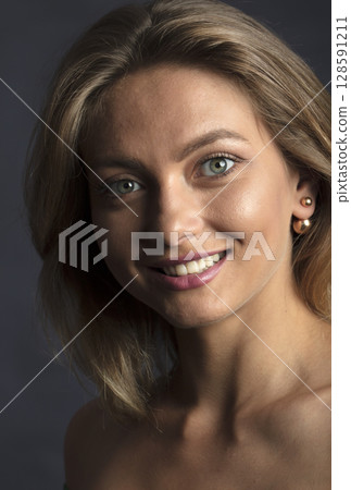 portrait of a young beautiful woman on a dark background portrait of a young beautiful woman on a dark background 128591211