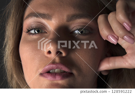 portrait of a young beautiful woman on a dark background portrait of a young beautiful woman on a dark background 128591222