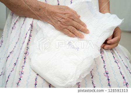 Asian senior woman patient wearing adult incontinence diaper pad in hospital. Asian senior woman patient wearing adult incontinence diaper pad in hospital. 128591313