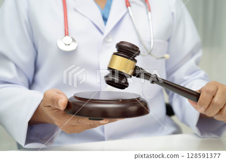 Asian doctor holding court hammer for and crime law justice, forensic medicine. 128591377
