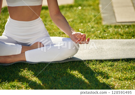 Close up view of woman that is sitting in lotus pose and meditating 128591495