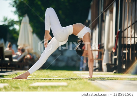 Side view. Young woman in yoga clothes is outdoors 128591502