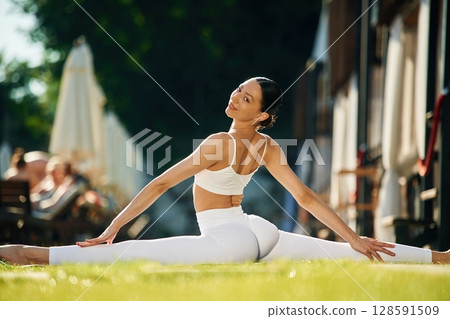 On the green grass. Young woman in yoga clothes is outdoors On the green grass. Young woman in yoga clothes is outdoors 128591509