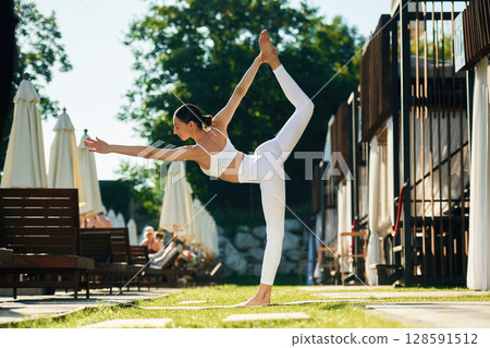 On the green grass. Young woman in yoga clothes is outdoors On the green grass. Young woman in yoga clothes is outdoors 128591512
