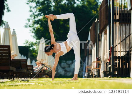 Long legs. Young woman in yoga clothes is outdoors Long legs. Young woman in yoga clothes is outdoors 128591514