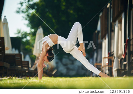 Long legs. Young woman in yoga clothes is outdoors Long legs. Young woman in yoga clothes is outdoors 128591536