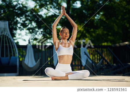 Young woman in yoga clothes is outdoors 128591561