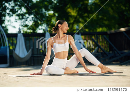 Taking a break, sitting. Young woman in yoga clothes is outdoors 128591570