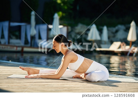 Doing yoga exercises. Woman near pool 128591608