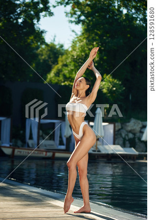 White underwear. Woman is standing near the pool White underwear. Woman is standing near the pool 128591680