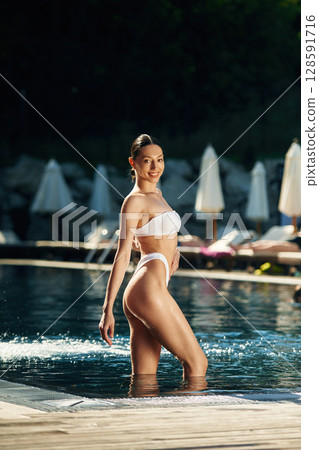 Positive woman in white underwear is in the pool Positive woman in white underwear is in the pool 128591716