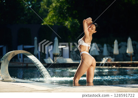 In white underwear. Woman is in the pool 128591722