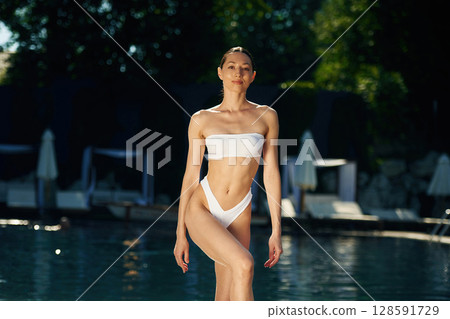 Fresh water, standing. Woman in white underwear is in the pool 128591729
