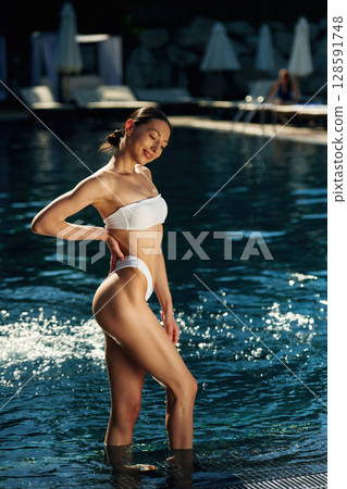 Woman in white underwear is in the pool Woman in white underwear is in the pool 128591748