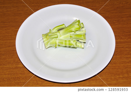 白盤子上的生西蘭花莖（木紋背景） 128591933