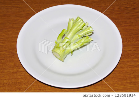 白盤子上的生西蘭花莖（木紋背景） 128591934