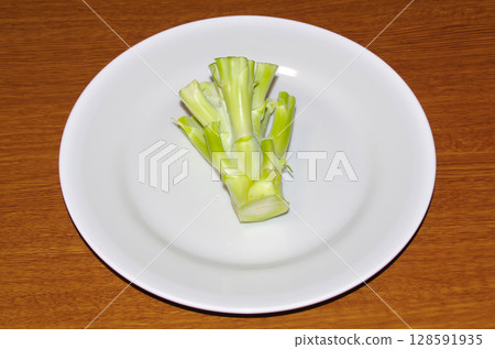 白盤子上的生西蘭花莖（木紋背景） 128591935