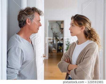 Caucasian father and teen daughter in thoughtful conversation at home. 128591981