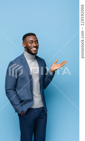 Cheerful african male adult in blue jacket gesturing on light blue background. Cheerful african male adult in blue jacket gesturing on light blue background. 128592008