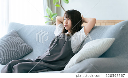 女人坐在客廳的沙發上思考 128592367
