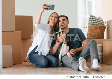 Making selfie. Young couple with dog are moving to new home 128592390