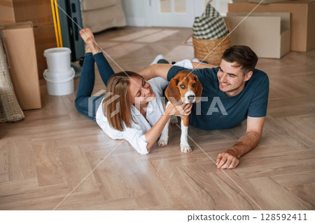 Playing with dog. Young couple is moving to new home 128592411