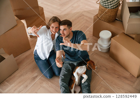 Top view. Young couple with dog are moving to new home Top view. Young couple with dog are moving to new home 128592449