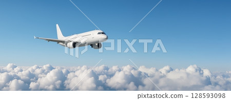 Passenger plane flying above fluffy clouds in clear blue sky. concept of air travel, freedom, aerial transportation. Banner with copy space 128593098