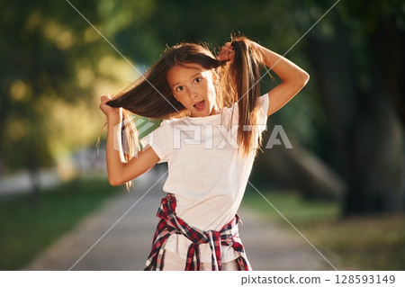 Playful emotions, having fun. Young girl in casual clothes is in the public park outdoors 128593149