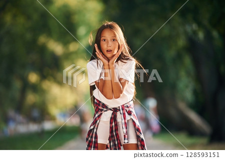 Shocked young girl in casual clothes is in the public park outdoors Shocked young girl in casual clothes is in the public park outdoors 128593151
