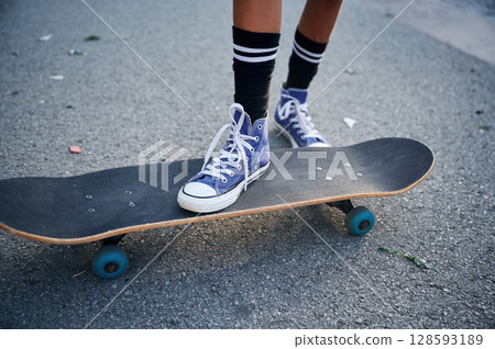 Close up view of skateboard riding by a young girl 128593189
