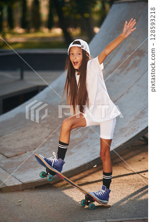 Conception of extreme sports. Happy little girl with skateboard outdoors 128593218