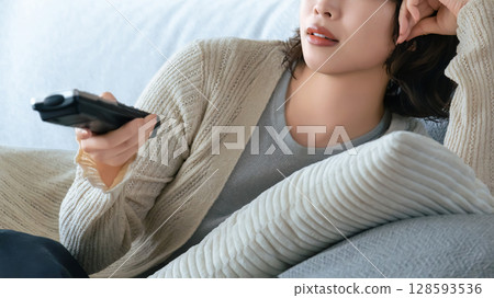 女人在沙發上看電視 128593536