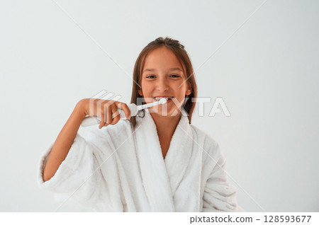 Cleaning the teeth. Conception of beauty and self care. Young girl is in the studio Cleaning the teeth. Conception of beauty and self care. Young girl is in the studio 128593677