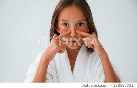 Orange colored eye patches on the face. Conception of beauty and self care. Young girl is in the studio 128593721