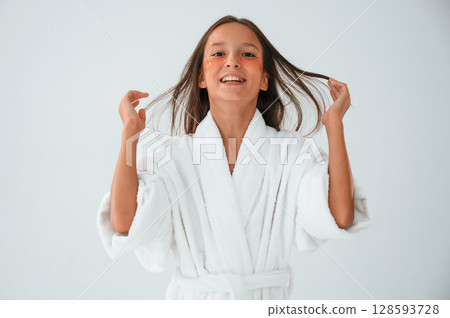 Young girl is in the studio using eye patches on the face Young girl is in the studio using eye patches on the face 128593728