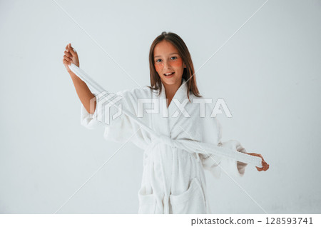 In white robe. Conception of beauty and self care. Young girl is in the studio In white robe. Conception of beauty and self care. Young girl is in the studio 128593741