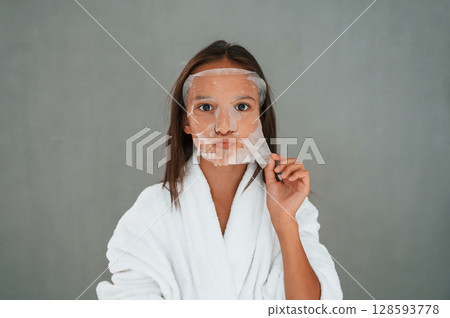 Cleaning mask is on the face. Conception of beauty and self care. Young girl is in the studio 128593778