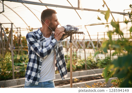 Young gardener is in the greenhouse 128594149