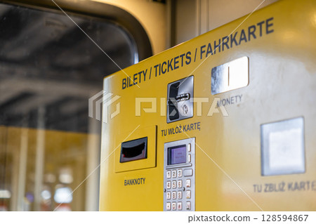 Yellow public transport ticket machine facilitates urban travel, accepts banknotes, coins, and cards, displaying TICKETS for convenient transactions Yellow public transport ticket machine facilitates urban travel, accepts banknotes, coins, and cards, displaying TICKETS for convenient transactions 128594867